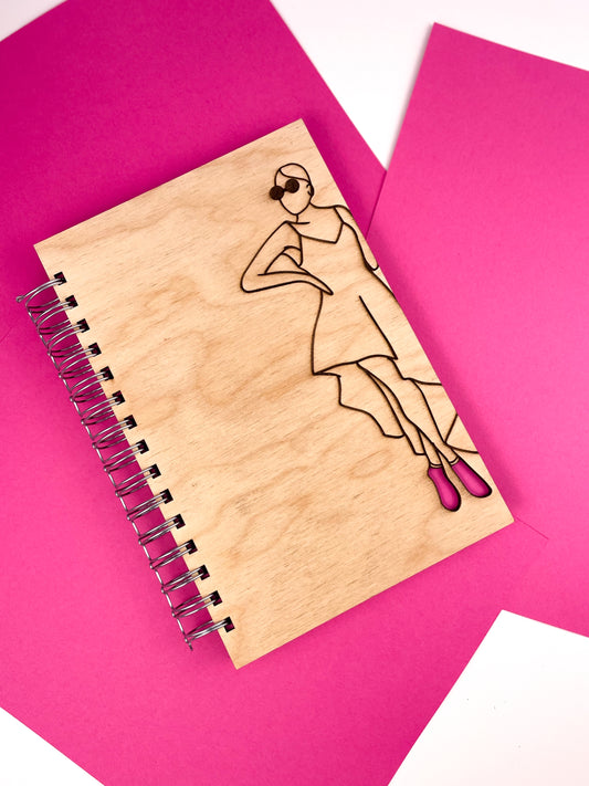 Glamorous woman wearing pink heels wooden notebook